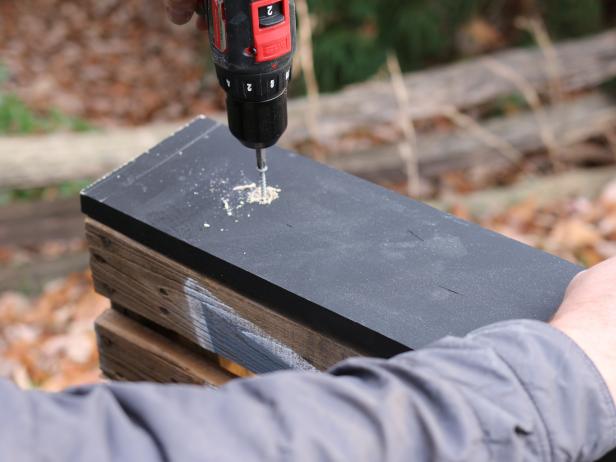 Use drill and 2â exterior wood screws to fasten the two shorter trim pieces to the sides of the pallet.