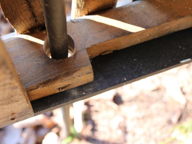 In order for the sign to stand up level along the ground, youâll need to create holes through the joists for threaded pipe. Attach 2â paddle bit to the drill, then create two holes, one on each side of each of the two joists. With the help of a friend, slide the pipe through the holes.
