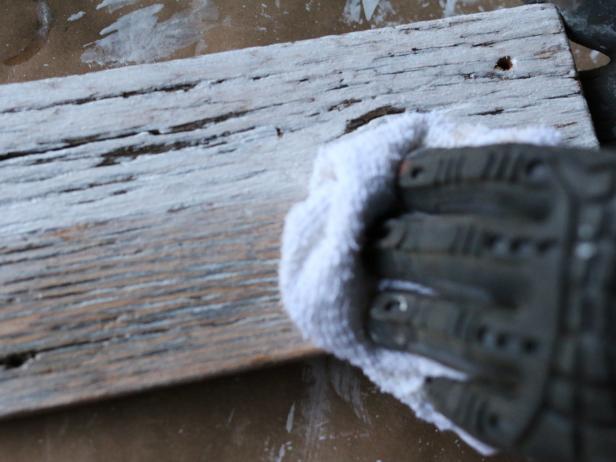 After a rustic wooden surface is covered with whitewash, use a damp cloth to remove some of the solution. This will allow more of the grain to show, resulting in a more organic finish.