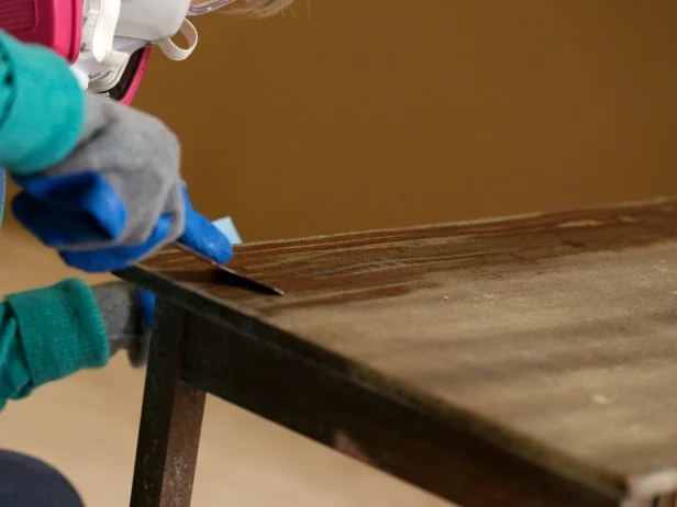 Next use your scraper tool to remove the old finish. Wipe the blade with a disposable shop cloth between scrapes. You may have to apply stripper and scrape more than once in order to remove the majority of the old finish. Once youâ re done stripping and the surface is dry, wipe with mineral spirits using a clean cloth to remove any residual stripper. Allow the table to fully dry before moving on to sanding.