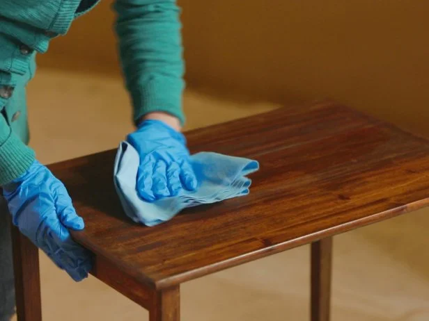 Next use your scraper tool to remove the old finish. Wipe the blade with a disposable shop cloth between scrapes. You may have to apply stripper and scrape more than once in order to remove the majority of the old finish. Once youâ re done stripping and the surface is dry, wipe with mineral spirits using a clean cloth to remove any residual stripper. Allow the table to fully dry before moving on to sanding.