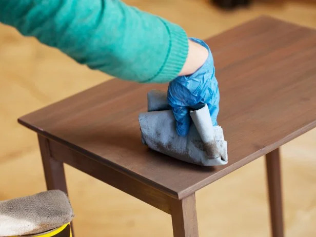 Then use a clean wiping cloth to remove excess stain. Wipe lightly with the grain to avoid streaking. Youâ ll need to apply multiple coats until you like the color. Keep following the same process but be sure to let the stain dry between coats so you can gauge what it looks like before deciding whether to add another coat.