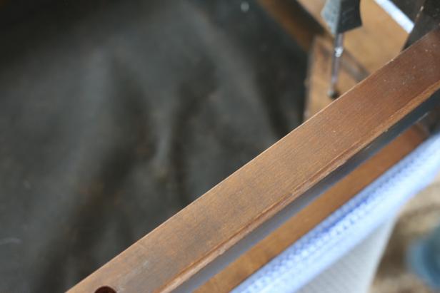 Using a screwdriver or drill, reattach the ottoman cushion to the frame or legs.