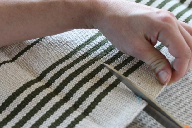 Use dressmaker shears to cut two of the flat weave rugs into top and bottom panels for the slipcover.
