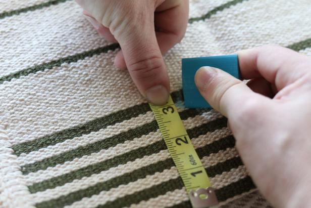 Using the height measurement of the pet bed as a guide, mark the rug to size using a marker or chalk.