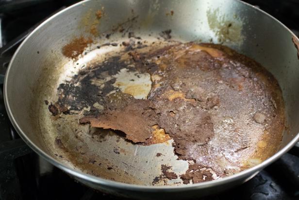 Cleaning a pan that is scorched or burnt with food.