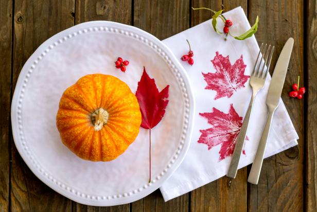 Leaf Print Napkins plate with pumpkin, leaf print napkin, and utencils