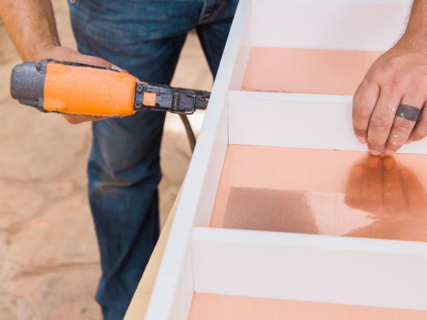 Step 5- Finish Assembly Slide the frame over the plywood and secure along the sides using a nail gun. Next, measure the width of the interior of the shelf and cut shelves from the 1x3 wood trim. Secure using a nail gun.