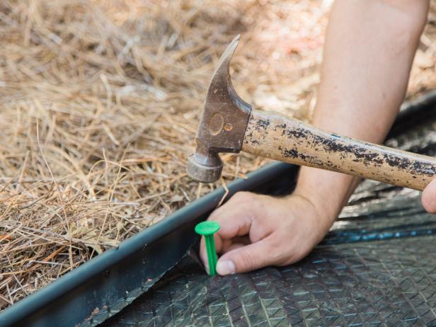 Step 4- Roll Out Weed BlockNext, roll out a weed block material over the pathway. Stake all the loose edges and trim excess with scissors.