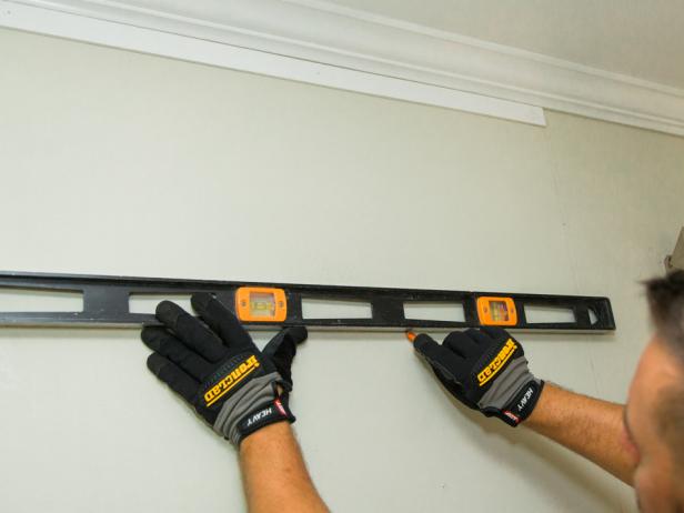 Step 3- Measure, Cut & Secure Horizontal StripsNext, measure the distance between the bottom and top horizontal strip, then divide that by three (how many horizontal boxes our design has) to determine where the center of the “channels” will be located- this is the space between the boxes, where strips where the cables will run. It’s easiest to create a .5 inch channel when it comes to doing the math for this project. Go ahead and mark on the wall using a level and pencil, as this area will eventually be covered. Then, secure remaining strips with the nail gun in the proper location on wall.