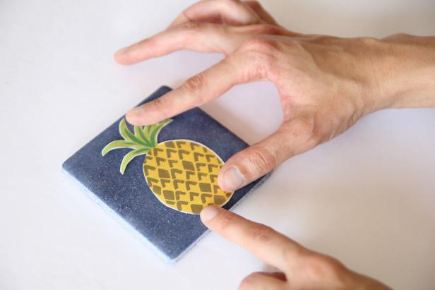 Place the cut out pineapple paper on the center of a square ceramic tile.