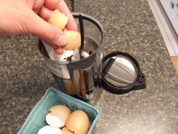 Putting Eggshells into Coffee Grinder Crushed Eggshells for Pest Control