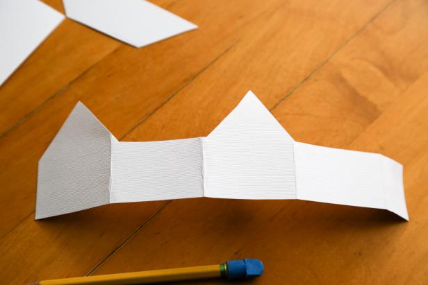 DIY Network shows you how to cut out the pattern like so for the paper houses.