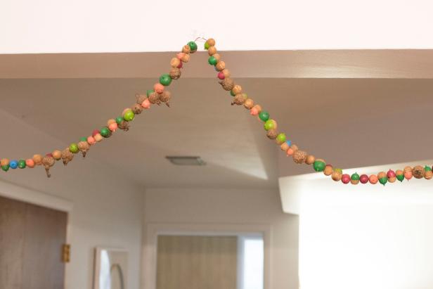 Upcycle Acorns Into a Colorful Fall Garland Upcycled acorns become a colorful fall garland.