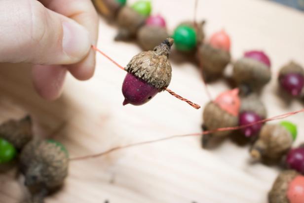 Upcycle Acorns Into a Colorful Fall Garland Upcycled acorns become a colorful fall garland.