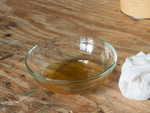 A bowl of finish on a workbench with a rag for rubbing out the finish A bowl of finish on a workbench with a rag for rubbing out the finish