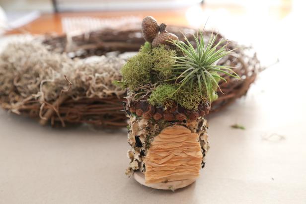 Make a House for the Fairy Wreath A tiny house covered with moss, lichen, and pinecones topped with an airplant.