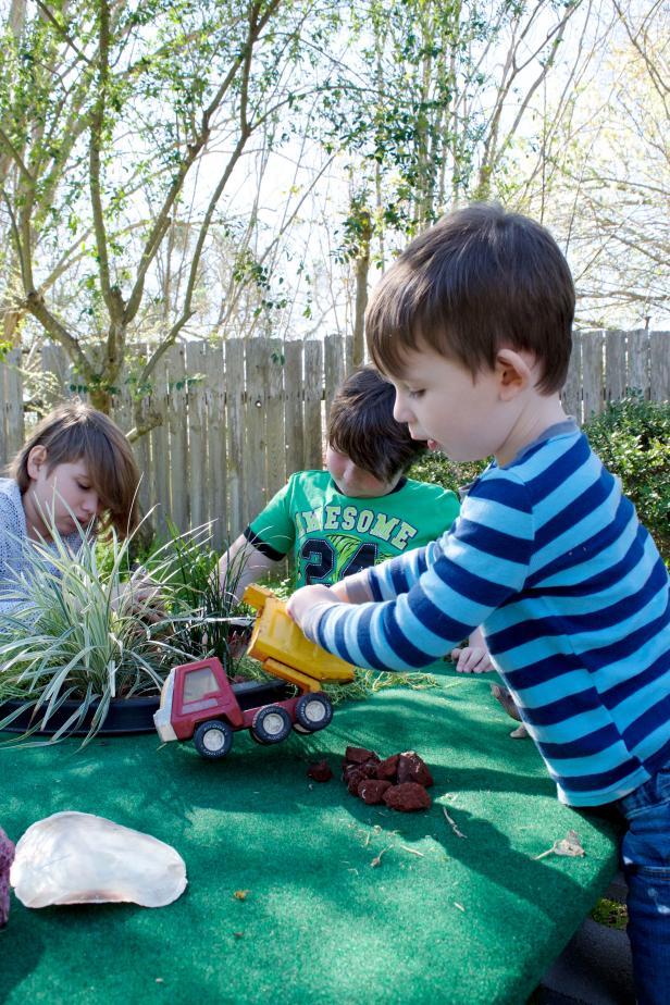 Kids Playing Outdoors Kid Filling His Toy Dump Truck Up With Painted Rocks Outside