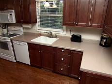 A kitchen with standard countertops and white appliances. The countertops will be remodeled with mini grante slabs.