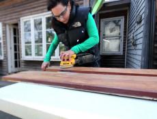 Joanne Palmisano sanding an old salvaged wood board.