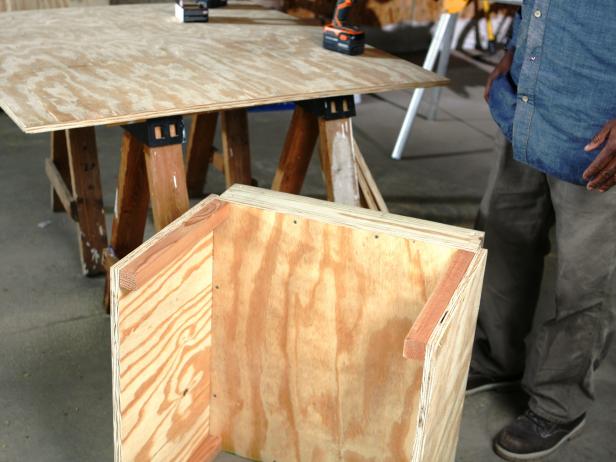 Constructing doghouse, side panels attached together.