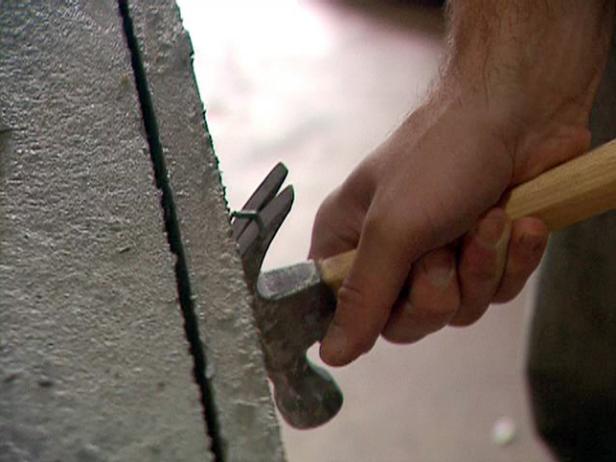 Carefully use a hammer and the new screws to pry each side away from the concrete slab.