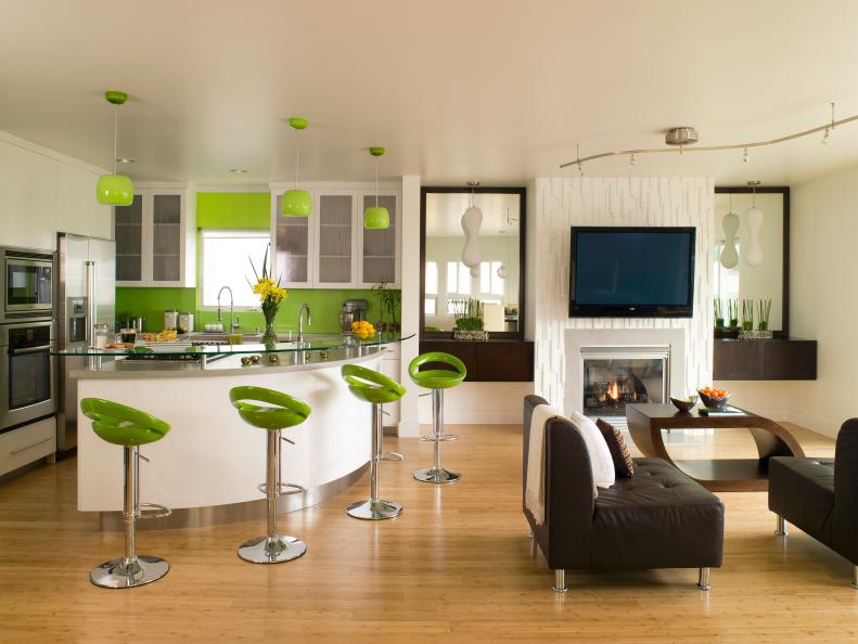 this eco friendly kitchen is green both literally and figuratively.green eco spec paint was used on walls and matched with modular bar stools and glass pendant lights.bamboo floors warm the room and top appliances with custom cabinetry make the room pop. 