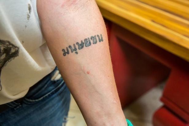 As seen on HGTV's Renovation Raiders, Amy Matthews (Liscenced Contractor) show off her tattoo. It says harmony in Thai. Amy got this tatto after working on Habitat for Humanity after the Katrina storm, and working on Habitat for Humanity in Thailand.