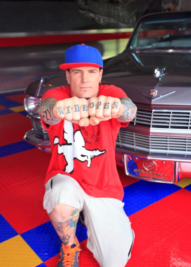 The interior garage space was created by host and licensed contractor by Rob Van Winkle (also know as Vanilla Ice) for his DIY Network’s original series The Vanilla Ice Project. Rob poses in front of his Cadillac showing of his new work.  Rob took the garage one step further creating a multi functional space.  Using the Racedeck snap lock flooring and installing a LaCantina hurricane accordion glass door that leads outside to a BBQ area with a Pergola covering from Backyard America this space can be used for many uses.  Don’t worry if your friends arrive at the house before you, just use the installed Liftmaster garage system and your smart phone from anywhere in the world to open the Copley garage doors to let them in.  As they what for you to arrive they can marvel at the custom mural airbrushed for Rob by Mike Gold. (Interior, portrait)