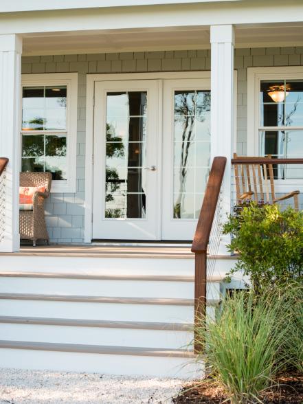 A cellular PVC-clad porch leads to the home's double French doors ...