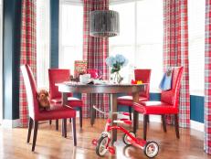 Previously void of color and pattern, the updated breakfast nook is packed with vibrant hues and graphic lines. The walls were painted the same shade of navy blue as the family room area and the windows are covered with the same drapery fabric and hardware, keeping the different spaces united for a cohesive look.