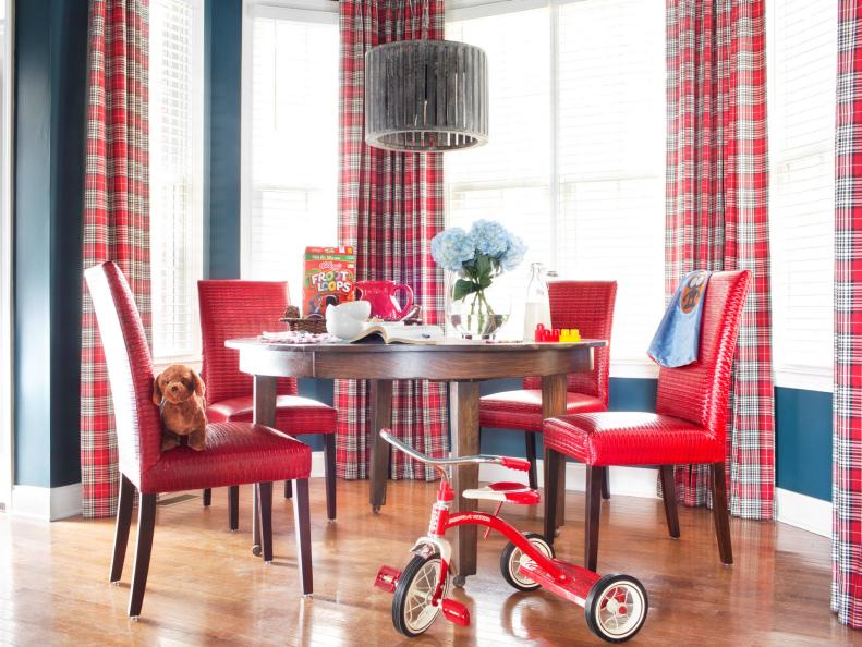 Previously void of color and pattern, the updated breakfast nook is packed with vibrant hues and graphic lines. The walls were painted the same shade of navy blue as the family room area and the windows are covered with the same drapery fabric and hardware, keeping the different spaces united for a cohesive look.