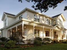 Traditional farmhouse features, oversized light fixtures and period-appropriate plantings make the front yard and porch pop.