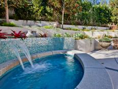 Hot Tub With Mosaic Wall, Waterfall & Concrete Edge