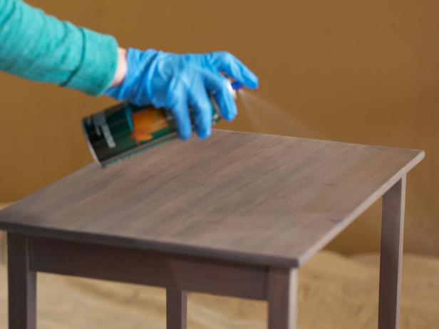 Once your last coat of stain is totally dry, apply an oil-based clear coat for a final layer of sheen and protection. Spray-on clear coat is easy to use and provides great coverage. Spray with a nice even motion following the natural lines of the piece. Apply two coats, sanding in between with 200 grit or higher sandpaper after the first coat is dry. This technique will smooth any imperfections from your first coat and give you a pro grade finish. Then spray on a final layer.