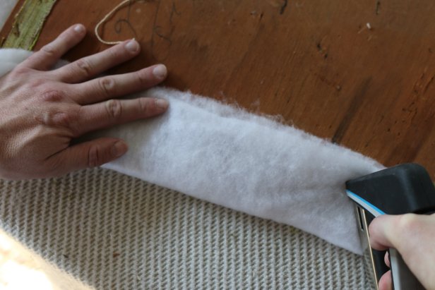 Unfurl batting, then cut it to size approximately 2 inches wider than the seat cushion using dressmaker shears. Stretch the batting across the top side of the cushion, then secure it to the back with the staple gun and 3/8-inch staples.