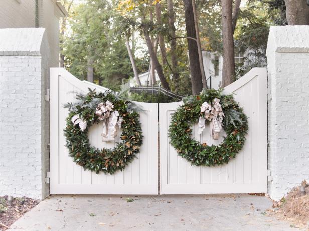 Large Magnolia Wreaths on wood gates of French Country white brick home