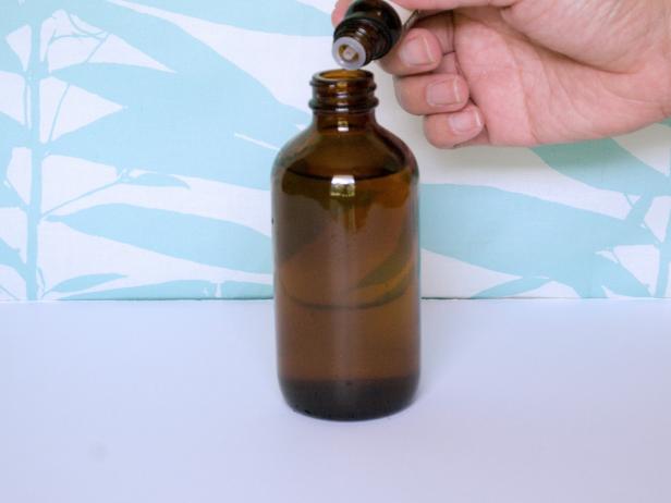Hand Adding Essential Oil to Brown Bottle