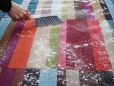 Using homemade carpet cleaner to clean a rug.