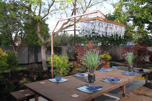 An eclectic chandelier hangs above an outdoor dining area, as seen on DIY Network's Yard Crashers.