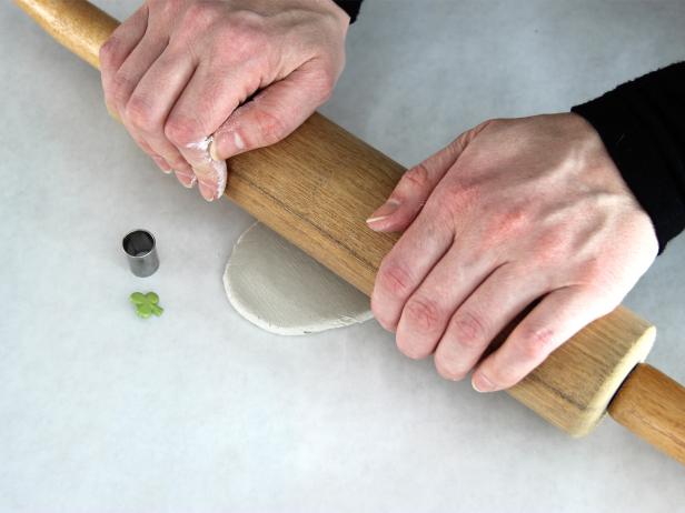Take a small chunk of the air dry clay and roll it out using the rolling pin.