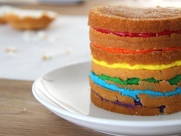 Continue the icing/cake layering process until each color of the rainbow is present and the topmost layer of cake is on top of the red icing. Chill in the fridge to firm.