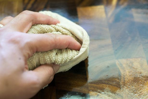 Hand Wiping Wood Cutting Board with a Towel