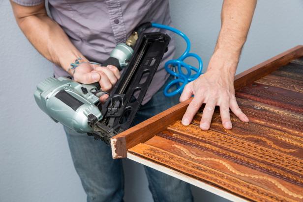 Use a nail gun to fasten the trim around the plywood of your leather belt headboard