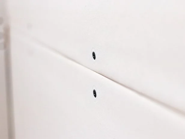 Feel the screw heads to make sure none are sticking above the surface of the drywall.