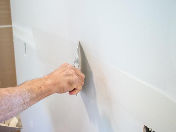 Use an 8" drywall knife to apply a thin finishing coat of joint compound.