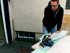 Contractor, Jeff Devlin uses a track saw to cut wood for a modern sliding barn door.